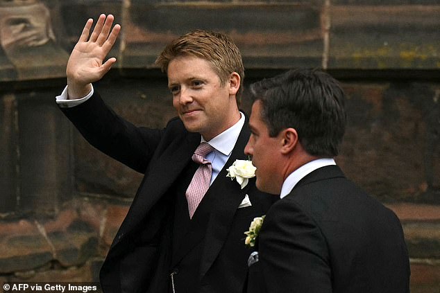 Hugh smiles and waves as he arrives at Cheshire Cathedral to marry Olivia.