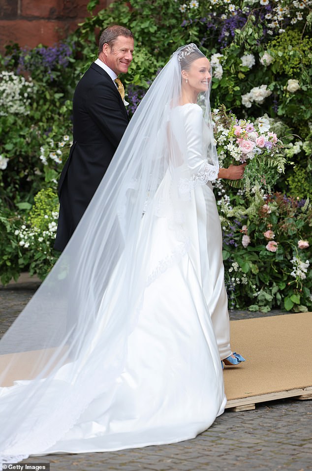 Olivia Henson smiles as she enters Chester Cathedral for her wedding to Hugh Grosvenor, Duke of Westminster.