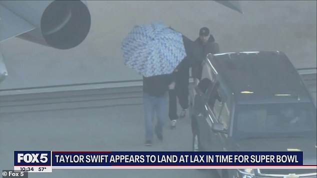 The singer used an umbrella to protect herself from the cameras while getting into a van.