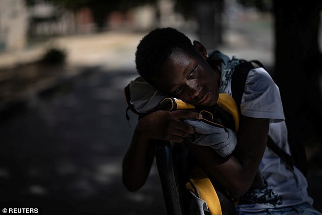 A person waits for the bus in the shade of a sidewalk as temperatures are expected to exceed 100 degrees Fahrenheit in Sacramento.