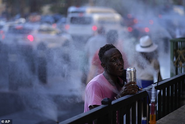 Cooling stations will be installed in Clark County for the public to find some relief during the day starting Wednesday. (Pictured: A man is seen cooling off in vaporizers along the Las Vegas Strip in July 2023)