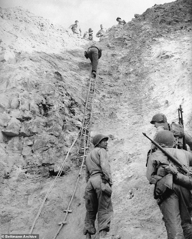 A group of U.S. Army Rangers demonstrate how they climbed a rope ladder up the cliff at Pointe du Hoc to surprise a Nazi gun position.