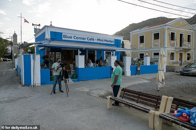 A camera crew is seen filming in front of the Blue Corner Cafe in Symi.