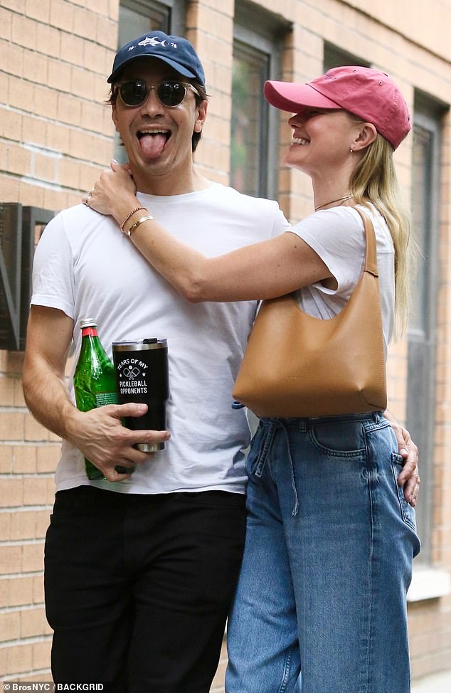 Justin managed to hold on to his beloved while juggling two drinks: a bottle of water and a thermos with the humorous label 