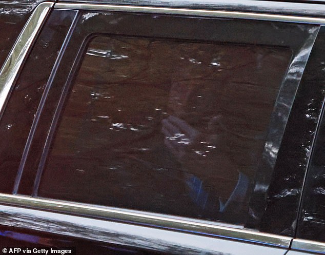 Donald Trump is seen through a car window blowing a kiss as he leaves the fundraiser