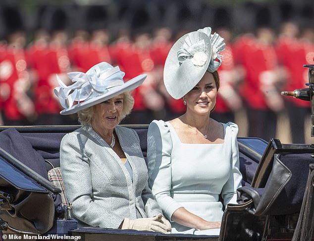 Camilla styled a light blue Fiona Clare coat and dress accessorized with classic yet statement pearl jewelry (in contrast to Kate's diamonds).