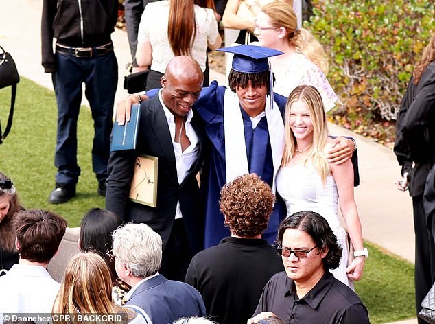 Seal looked dapper in a black suit and white shirt, while his girlfriend Laura turned heads in a white and gray striped midi dress.