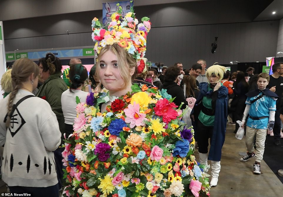 This attendant was covered in a cape of bright flowers with a matching flower crown.