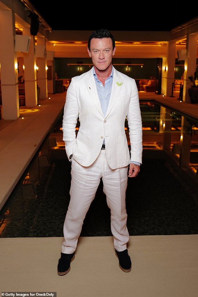 Hollywood star Luke Evans cut a smooth figure in a white suit ensemble and a light blue shirt.