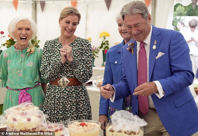 The royal (pictured, centre) smiles as she looks at some of the sweets on display, accompanied by Dame Mary Berry (pictured, left) and Alan Titchmarsh (pictured, centre).