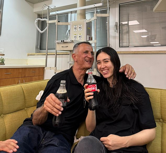 Noa smiles while having a drink of Coca-Cola with her father Yakov after meeting again on Saturday