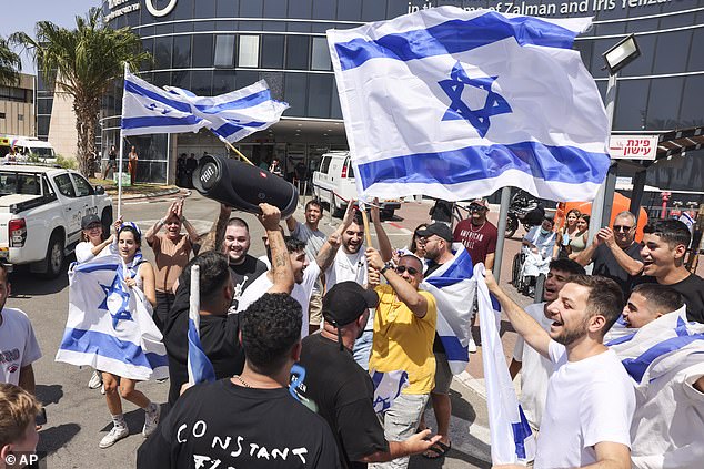 People wave Israeli flags as they celebrate after hostages who were kidnapped in a Hamas-led attack on October 7 were rescued from the Gaza Strip.