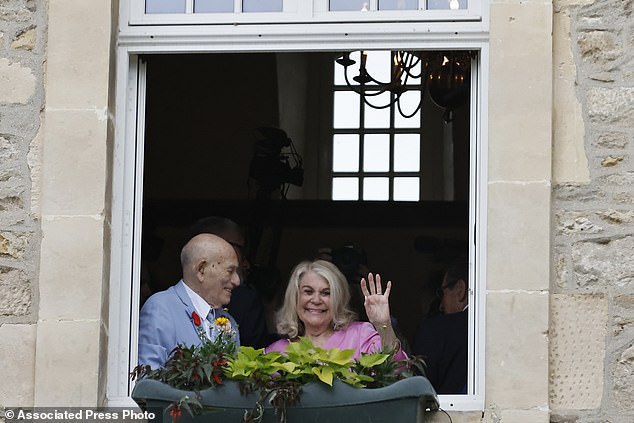 Terens, left, and Jeanne Swerlin, 96, smile from a window after celebrating their wedding at the town hall in Carentan-les-Marais, in Normandy, northwest France, where they were married by the mayor.