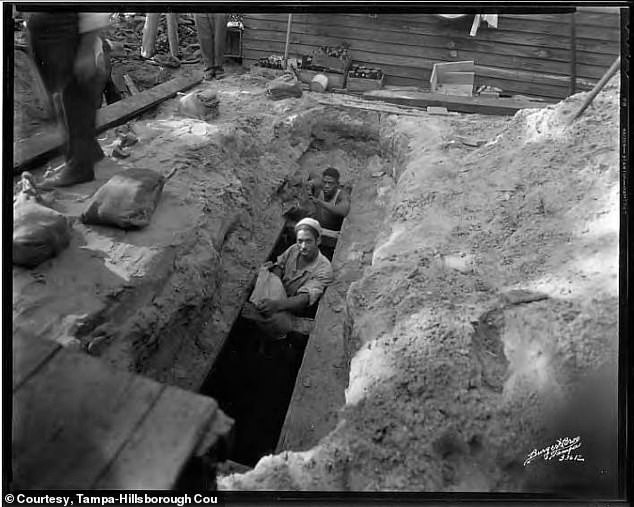 This undated photo shows federal authorities unearthing a cache of whiskey buried in the backyard of a Ybor City home.