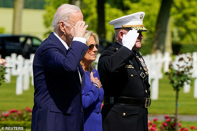 President Joe Biden waves and First Lady Jill Biden holds her hand on her heart as Taps plays at the Aisne-Marne American Cemetery in Belleau, France.