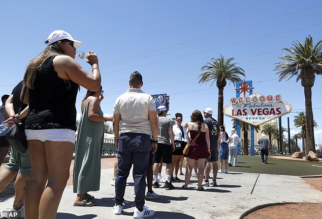 People drinking water while visiting the iconic Welcome to Fabulous Las Vegas sign on June 6. Temperatures are expected to reach 100 degrees as Trump holds a rally in the city on Sunday.