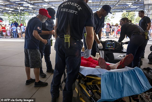 A Trump supporter is treated for exhaustion Thursday in Phoenix after crowds waited for hours outside the event, held at a megachurch, as temperatures reached 110 degrees.