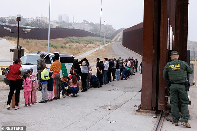 US Border Patrol agents round up and classify migrants who gathered overnight between the primary and secondary border walls separating Mexico and the United States following the announcement of tough new restrictions imposed by President Biden.