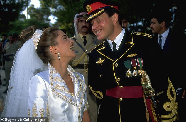 Although tradition dictates that royal brides wear family jewelry, Rania, born into a humble Palestinian family in Kuwait, made a statement by wearing a simple ornate headband attached to her veil, symbolizing her roots. Above: The couple smiles at each other on their wedding day.