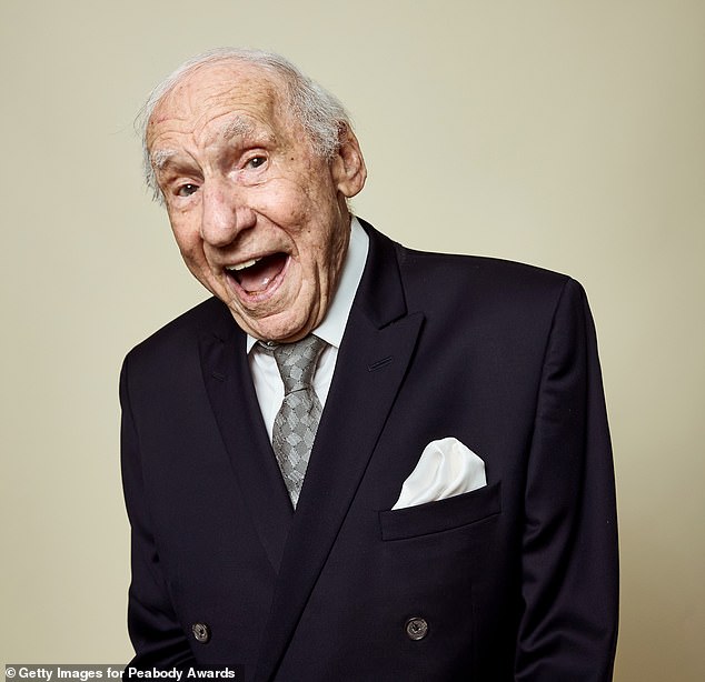 Brooks, who will turn 98 on June 28, stopped to pose for cameras before the ceremony, dressed in a black double-breasted suit, a short white dress and a gray patterned tie.