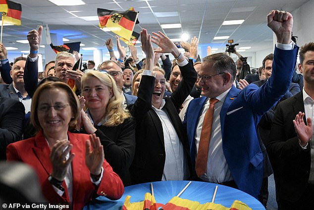 Members of Germany's far-right AfD party applaud after the first exit polls were announced.