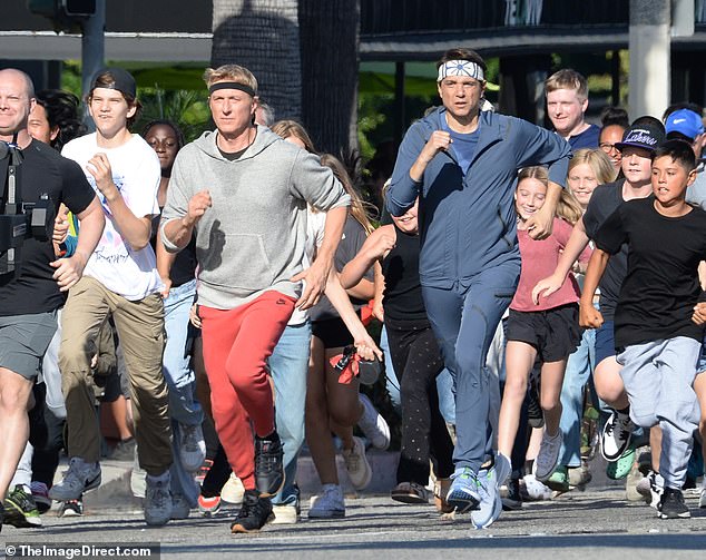 The co-stars donned sweatshirts and their signature martial arts headbands as they led a group of actors in a race through the streets of Encino.