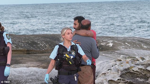 Emergency services attended the scene to begin a search and rescue operation. In the photo, passers-by comfort each other after two women drowned.