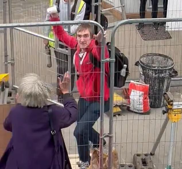 The protester, dressed in a red hoodie, throws a cup of coffee in the direction of the Reform Party leader.