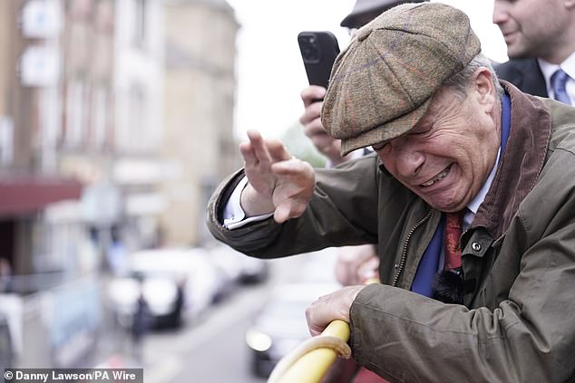 Farage grimaces as objects are thrown at him today in Barnsley, South Yorkshire