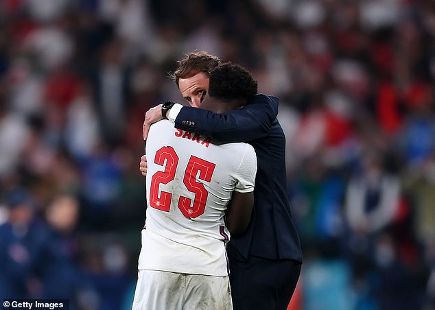 Bukayo Saka (front) hugs Gareth Southgate (back) after missing a penalty during the Euro 2020 final. The England star was subsequently insulted online after the match.