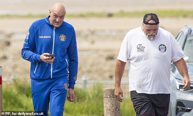 Fury was pictured with his father John (right) in his hometown after the fight.