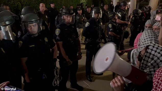 Seconds before the protester with the megaphone was suddenly pulled out of the crowd and arrested