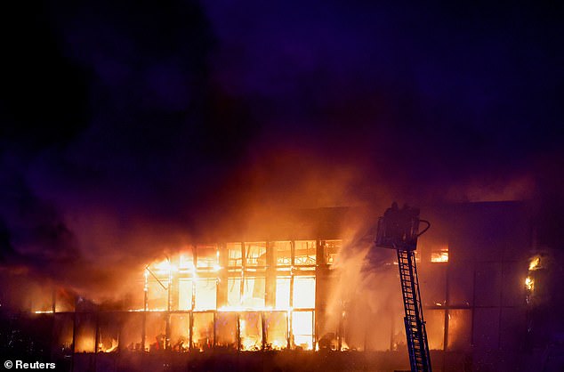 Rescuers work to extinguish the fire at the burning Crocus City Hall concert venue following a shooting, outside Moscow, Russia, on March 22, 2024.