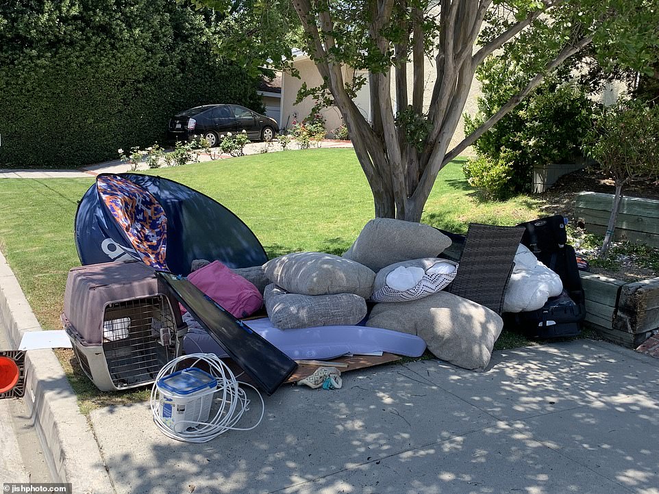 Piles of discarded furniture, cushions and other household items from the house were scattered outside on an otherwise well-kept residential street.