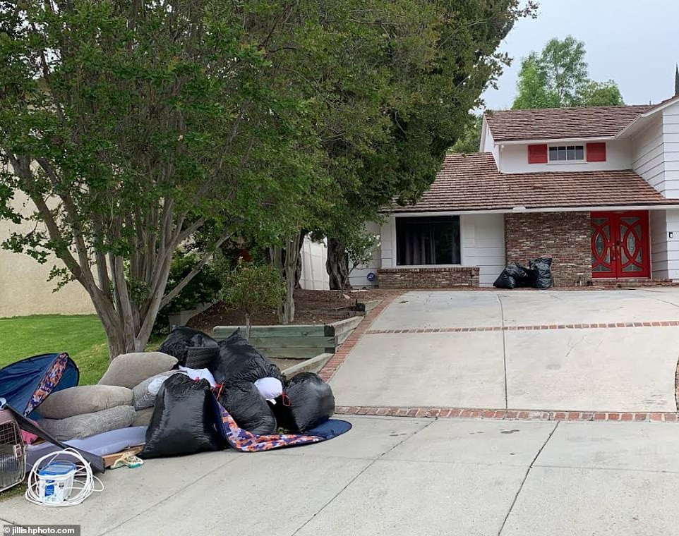 Several black trash bags that were also thrown out during the move can be seen littering the driveway of the home.