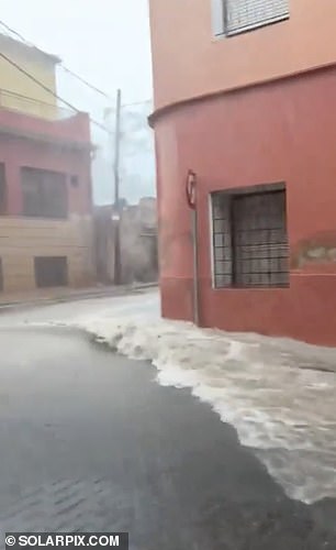 Water is seen rushing through the streets of Murcia on Monday as the southeastern region of Spain was hit by torrential rain.