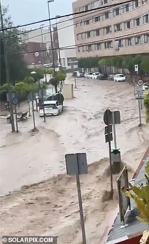 Water is seen rushing through the streets of Murcia on Monday as the southeastern region of Spain was hit by torrential rain.