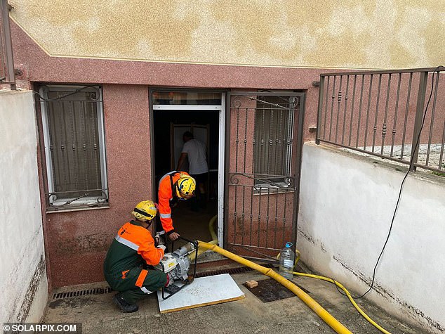 Lifeguards work to pump water from a building in Murcia