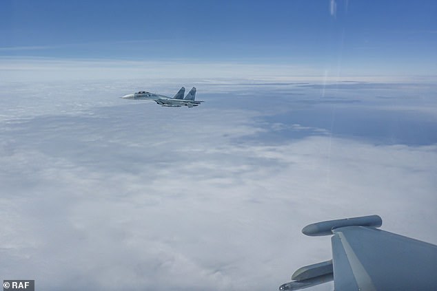 Last week, the UK's Typhoon jets teamed up with the German Air Force to intercept another Russian spy plane and a pair of fighter jets over the Baltic Sea. Pictured: A Russian Su-27 is seen flying off the wing of an RAF aircraft last week.