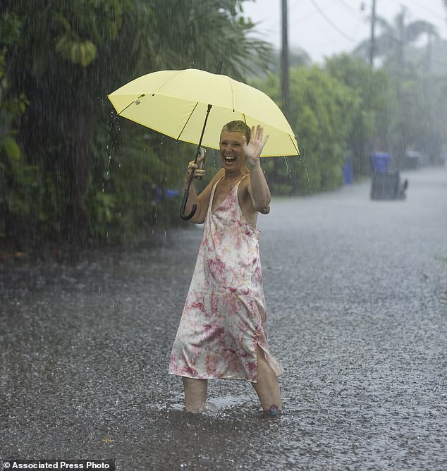 Laura Collinhofer holds an umbrella after moving her cars to higher ground as heavy rain falls over parts of South Florida on Wednesday, June 12, 2024, in Hollywood, Florida.