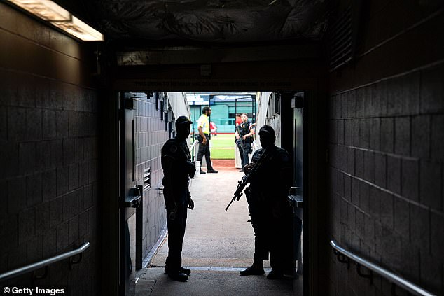 In the Nationals Park tunnel before the game, a police officer holds his gun.