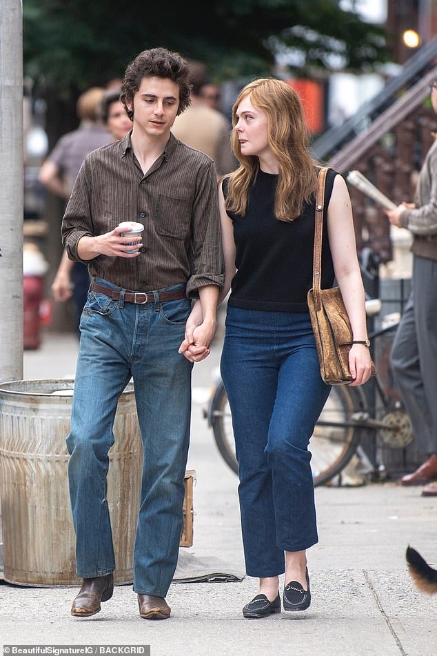 Timothée was wearing a brown striped button-down shirt with his sleeves rolled up. He tucked it into some baggy jeans with a thin brown belt and added a pair of distressed dark brown cowboy boots.