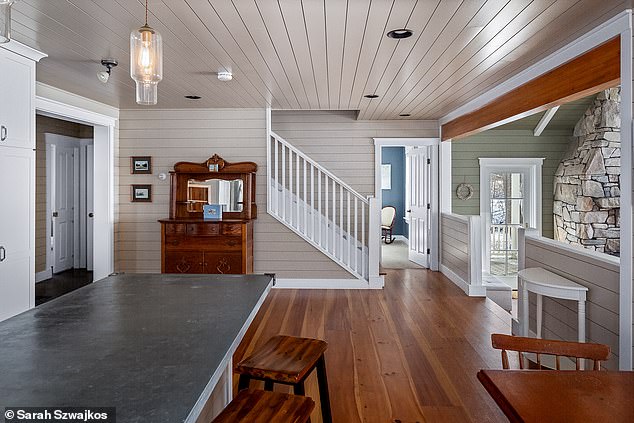 Just off the living room is a large eat-in kitchen with the same hardwoods, overhead lighting, slate countertops, and a zinc-clad island.