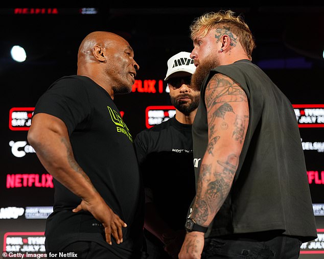 Mike Tyson, Nakisa Bidarian and Jake Paul pose on stage during a press conference on May 16.