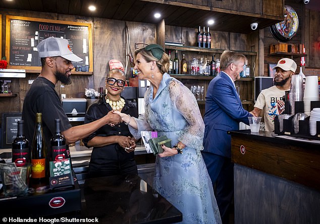 Queen Máxima shakes hands with a local business owner at a coffee shop in East Flabush.