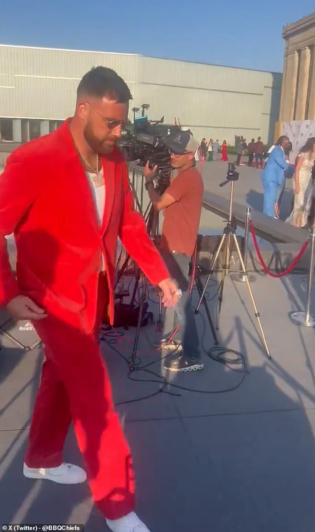 The Super Bowl champion opted for an all-red suit, with a 'TK' ornament around his neck.