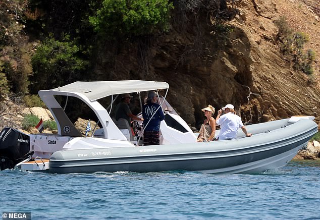 The boat sailed through the stunning blue waters near rocky cliffs.