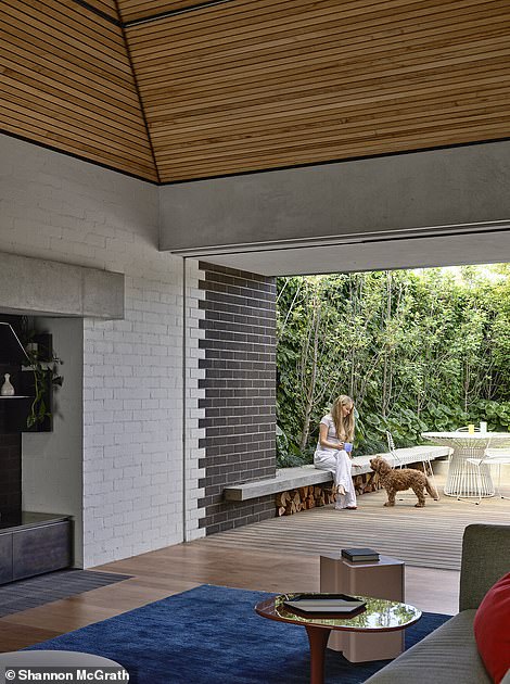 The impressive living room is separated from the main house by an internal herringbone brick path and is a unique gray brick structure in which an angled timber-clad roof slopes towards a skylight to let in daylight. sun.