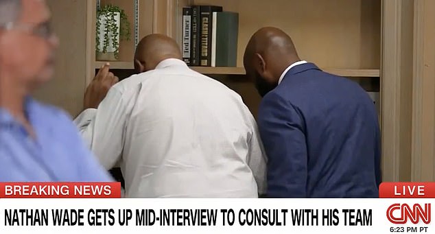 The media advisor (left) and Nathan Wade (right) huddled in a corner of the room while CNN kept cameras rolling. When he returned he continued to refuse to give a direct answer about the timing of his romance with Fani Willis.