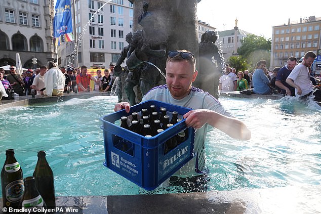 A Scottish fan standing at a fountain in Marienplatz square was seen pouring beers in and out